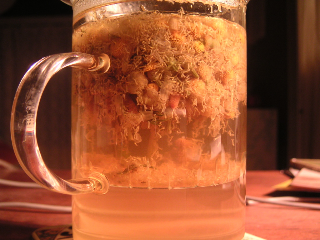 A clear glass of golden brewed chamomile tea