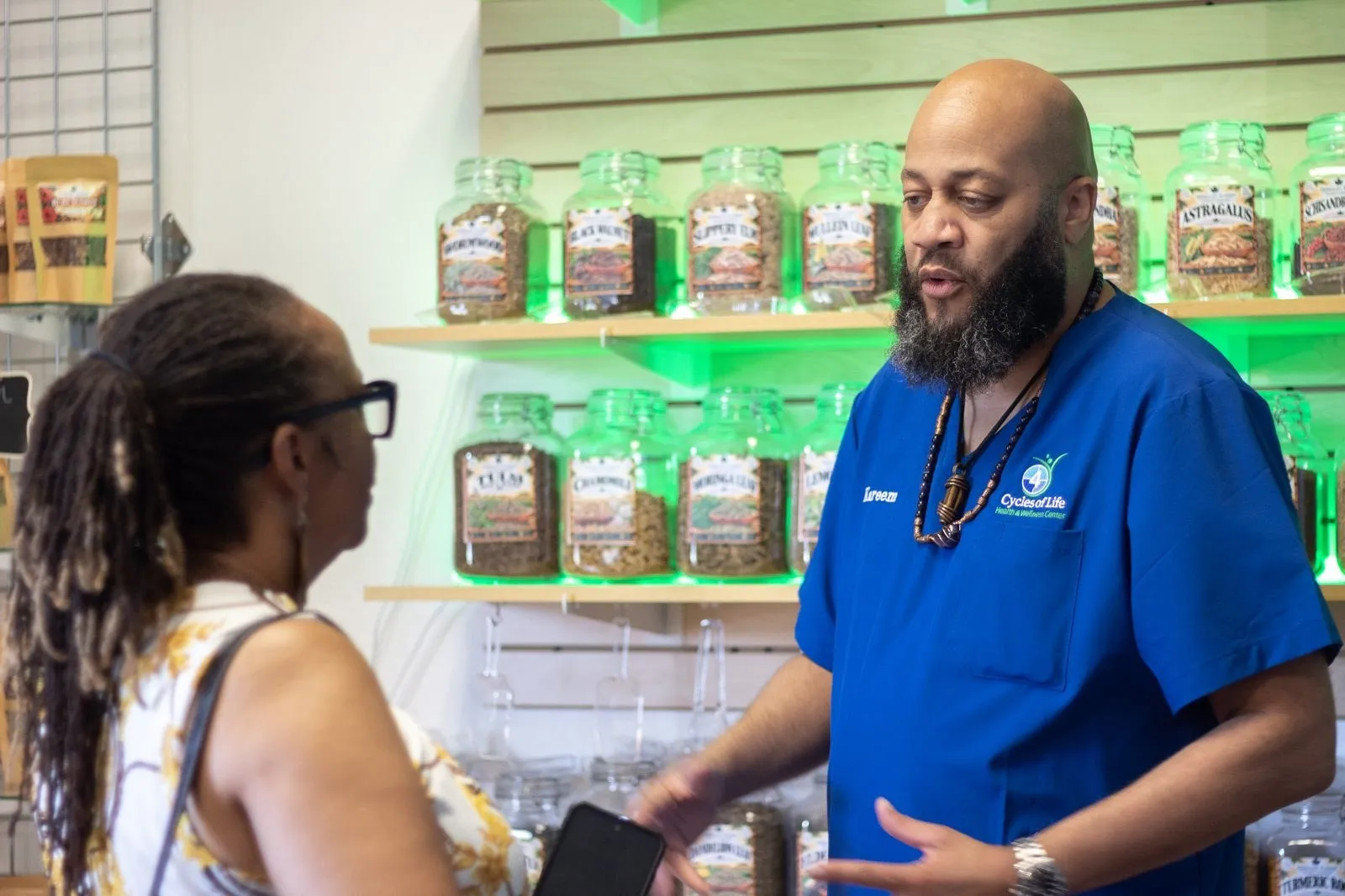 Herbalist Kareem helping a customer build a custom tea
